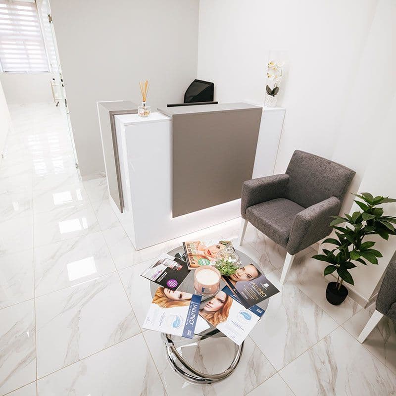 Reception and waiting area with brochures on a glass table at Hollywood Smile