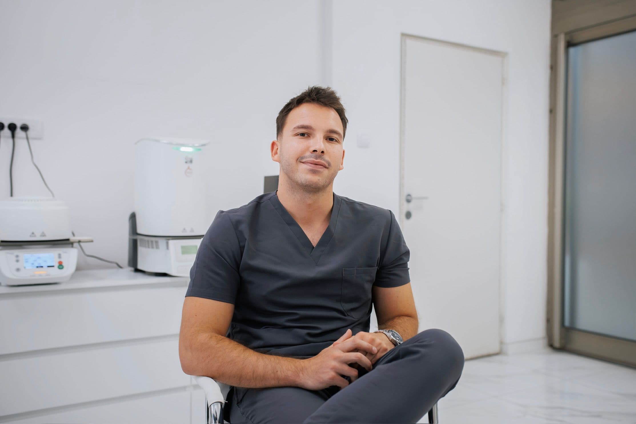 Dentist in dark scrubs seated in the Hollywood Smile clinic